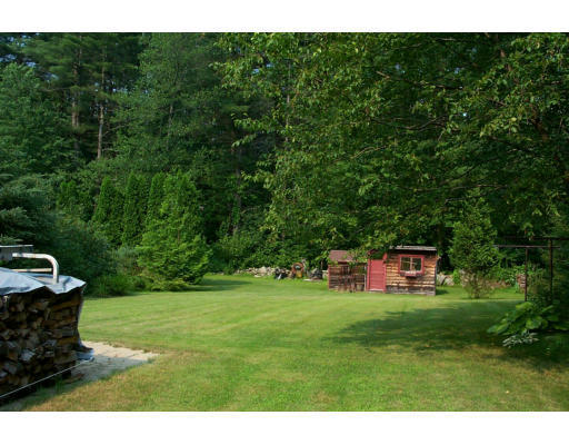 52 Gates Pond Road Berlin, MA 01503 - Photo 9 of 9 a backyard of a house with plants and large trees