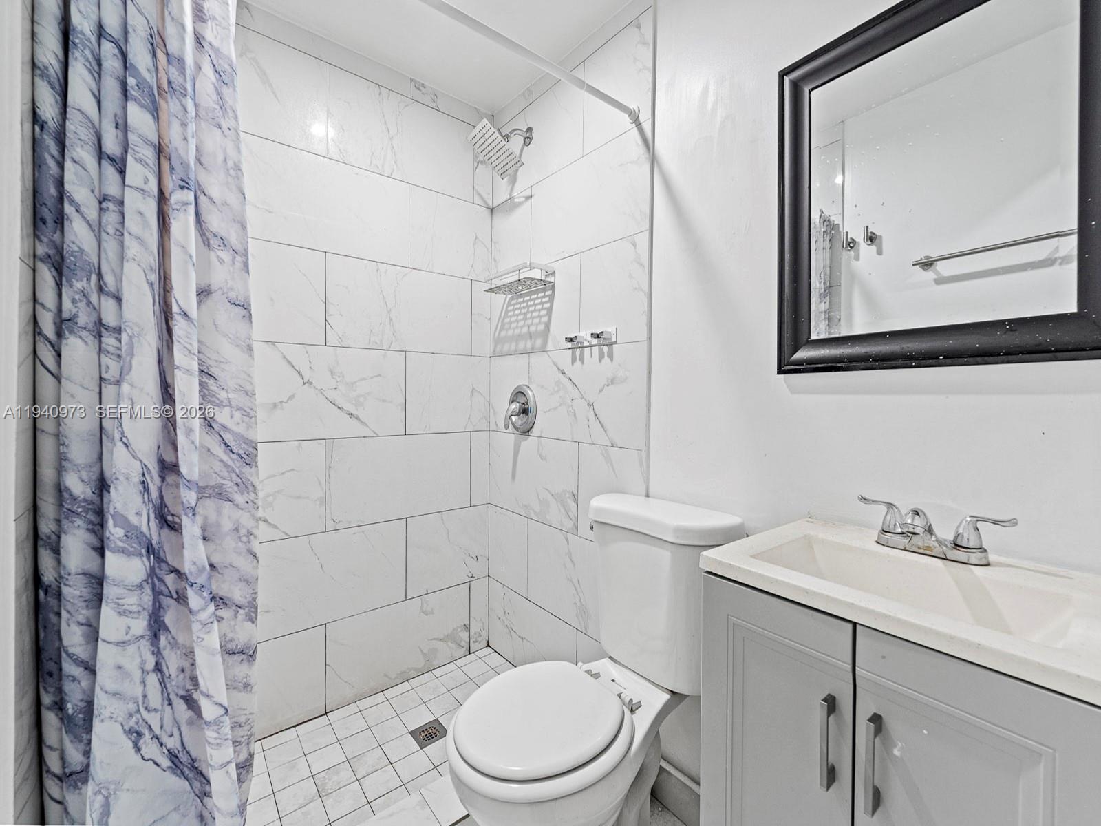 1230 Northwest 35th Street Miami, FL 33142 - Photo 20 of 36 a bathroom with a toilet sink and mirror