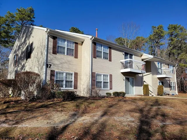 a view of a white house with a yard