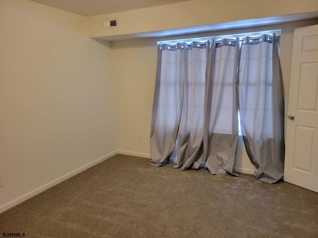 99 Club Place, Unit 99 Galloway Township, NJ 08205 - Photo 14 of 24 an empty room with wooden floor and windows