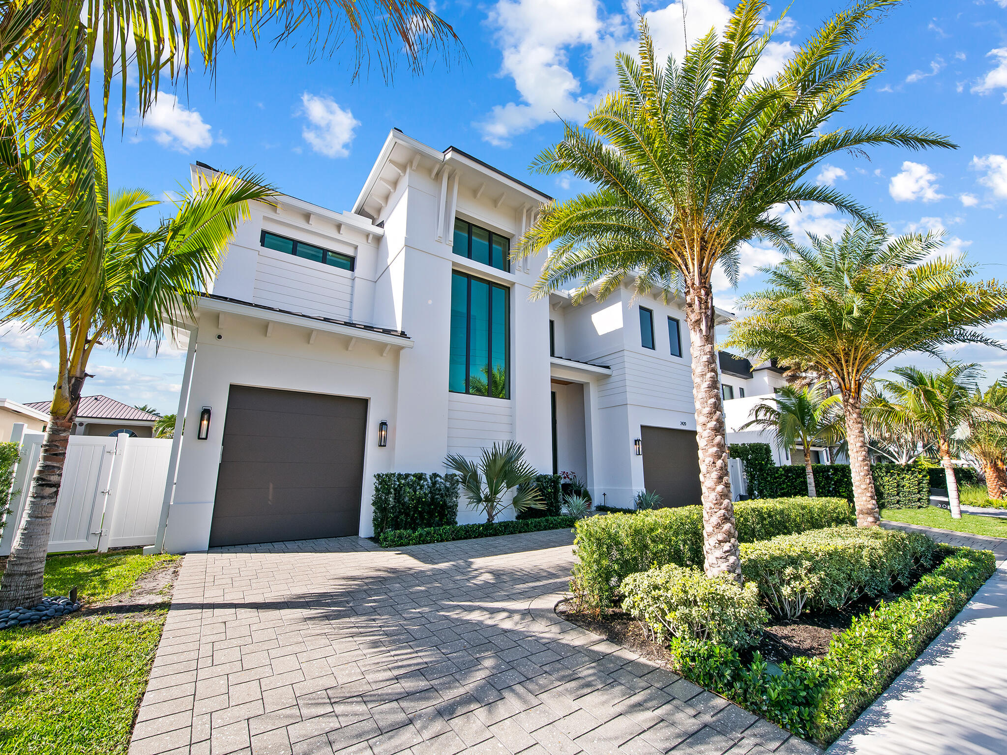 a front view of a house with a yard and potted plants