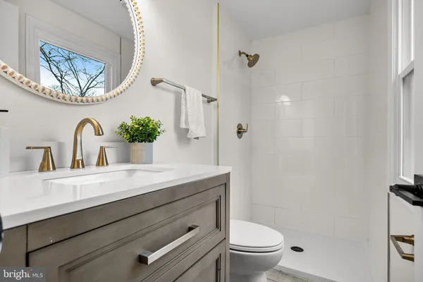a bathroom with a sink a toilet and a mirror