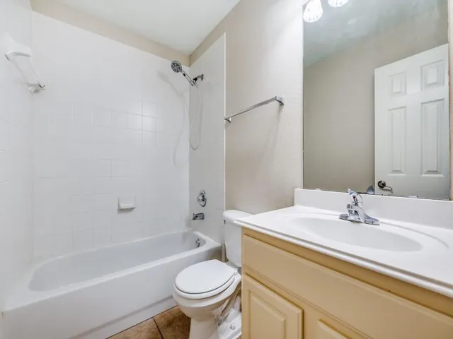 a view of an empty room with a chandelier fan