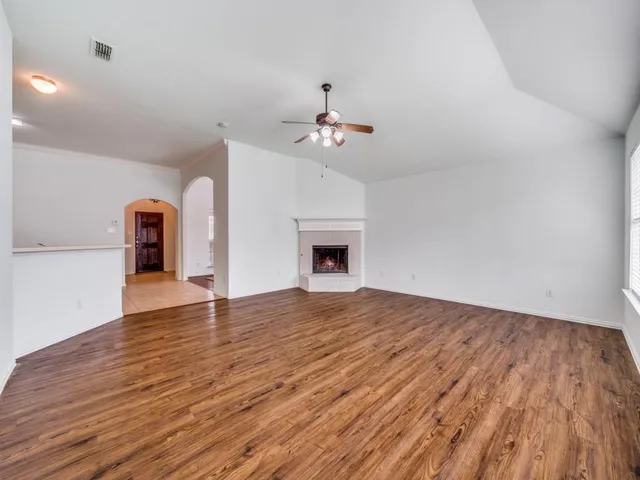 a view of an empty room window and wooden floor