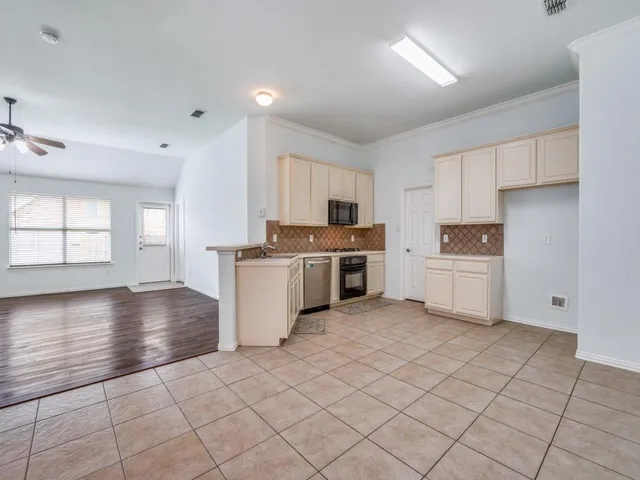 a kitchen with granite countertop white cabinets and stainless steel appliances
