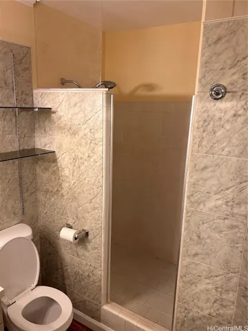 a bathroom with a toilet and a shower