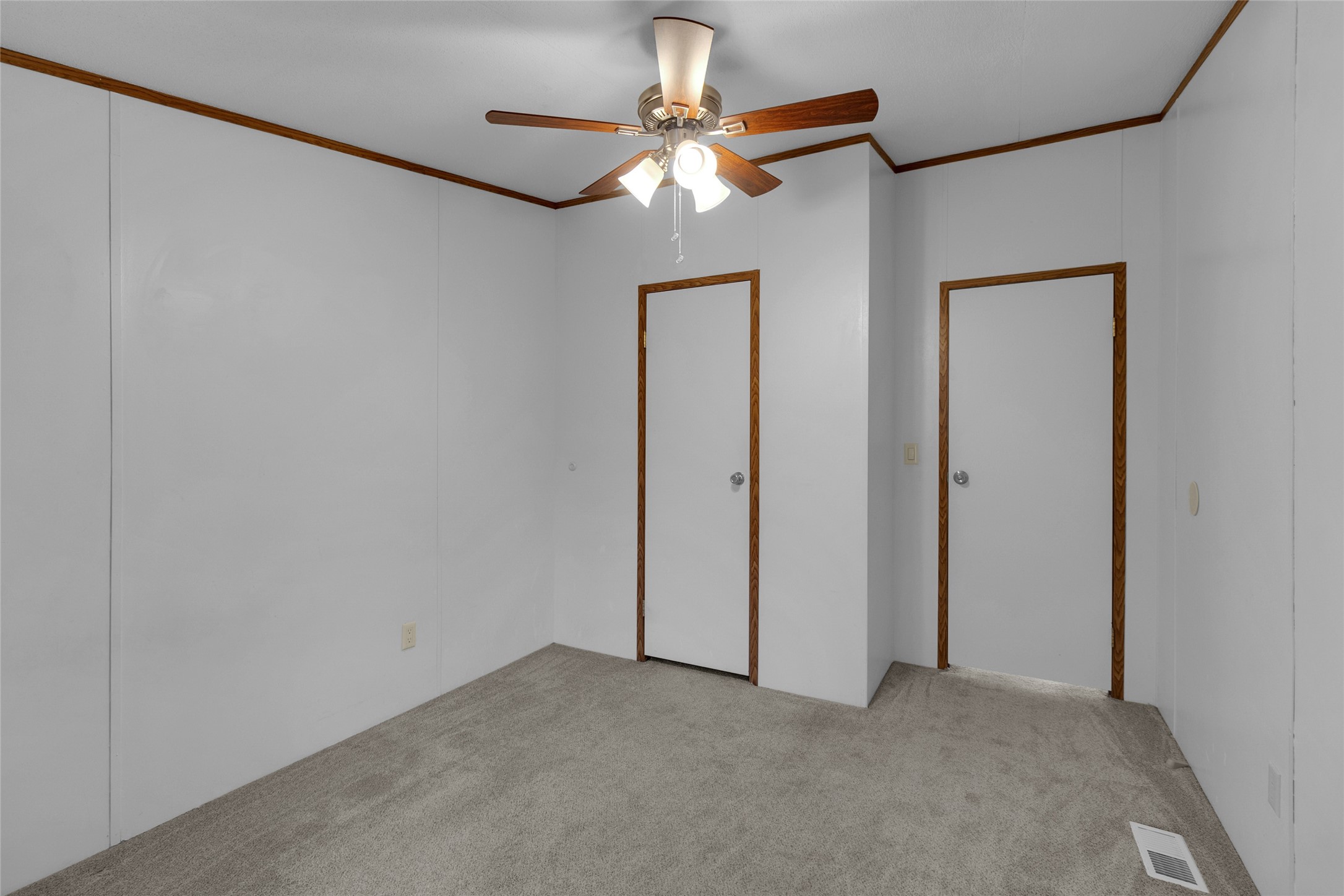 22094 Spear Road Porter, TX 77365 - Photo 33 of 45 The second bedroom showcases neutral-colored walls complemented by wood trim and carpeted flooring. It features a ceiling fan with lighting and two doors, one providing access to the room and the other leading to a conveniently sized, functional closet.