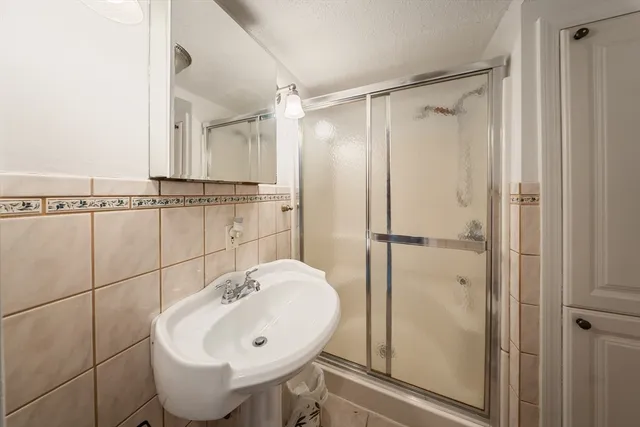 a bathroom with a sink mirror and shower