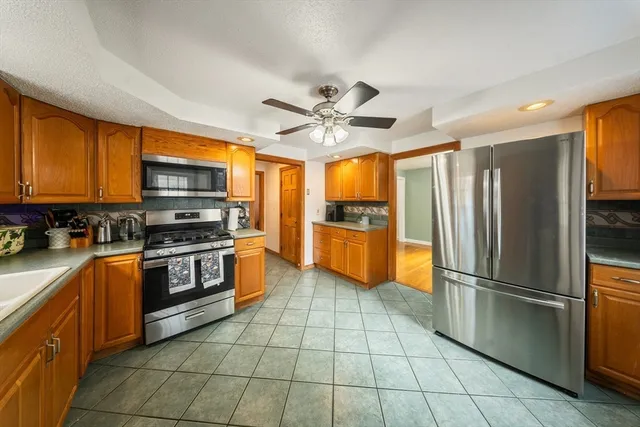 a kitchen with stainless steel appliances granite countertop a refrigerator oven a sink dishwasher and a refrigerator
