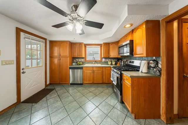 a kitchen with stainless steel appliances granite countertop a stove top oven a refrigerator a sink and dishwasher