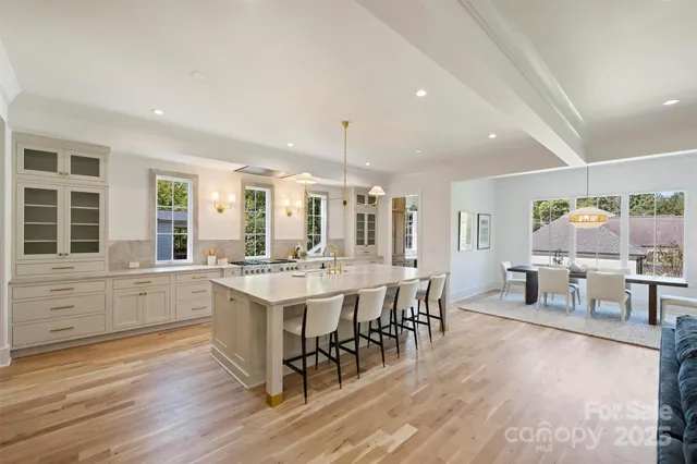 a large white kitchen with lots of counter space and view of living room