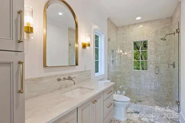 a bathroom with a granite countertop sink toilet and shower