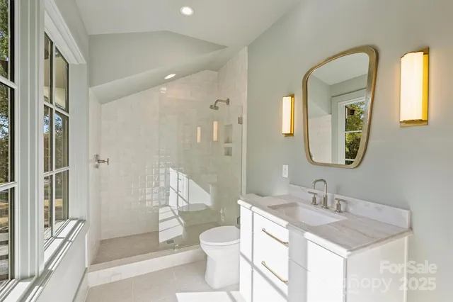 a bathroom with a granite countertop sink toilet a mirror and shower