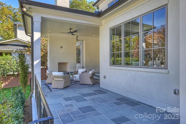 a balcony with chairs and a potted plant