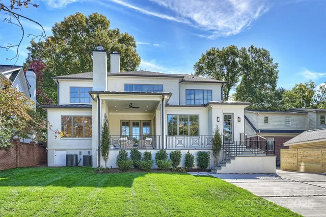 a front view of a house with a yard and potted plants