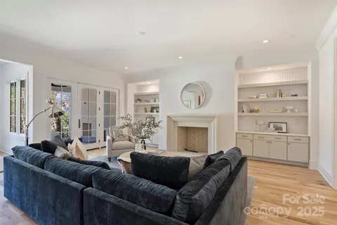a living room with furniture a fireplace and a open kitchen view