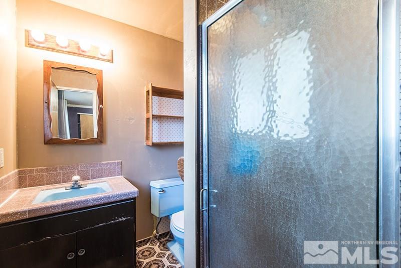 1430 Alturas Avenue Reno, NV 89503 - Photo 7 of 15 a bathroom with a granite countertop sink a toilet and shower