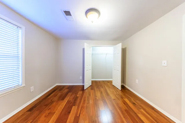 a view of a room with wooden floor and a window