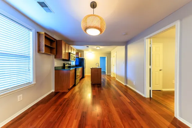 a view of a hallway with wooden floor