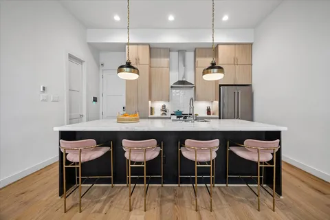 a dining room with wooden floor a chandelier a wooden table and chairs