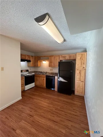 a kitchen with granite countertop a refrigerator and a stove