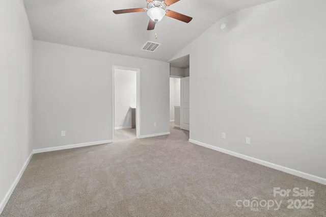 en empty room with ceiling fan and window