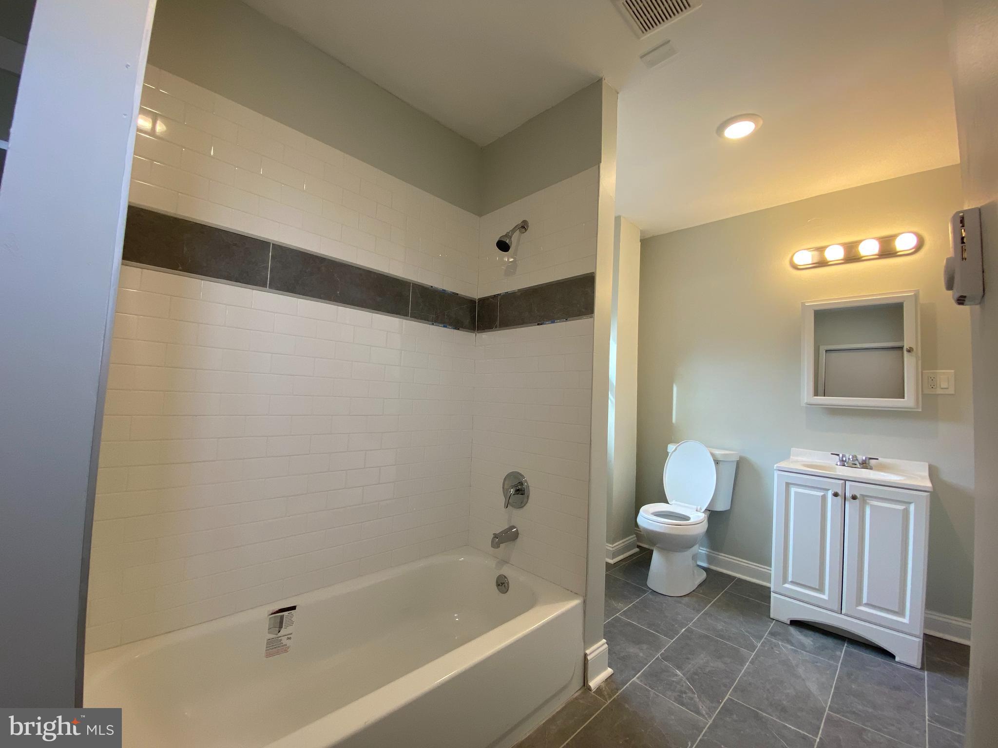 21 East Price Street, Unit 2R Philadelphia, PA 19144 - Photo 3 of 4 a bathroom with a sink a toilet and a bathtub