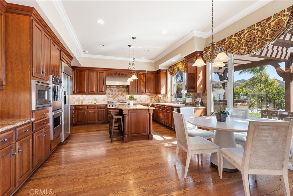 24920 Paseo Del Rancho Calabasas, CA 91302 - Photo 20 of 61 a kitchen with stainless steel appliances kitchen island granite countertop a table chairs and a view of living room