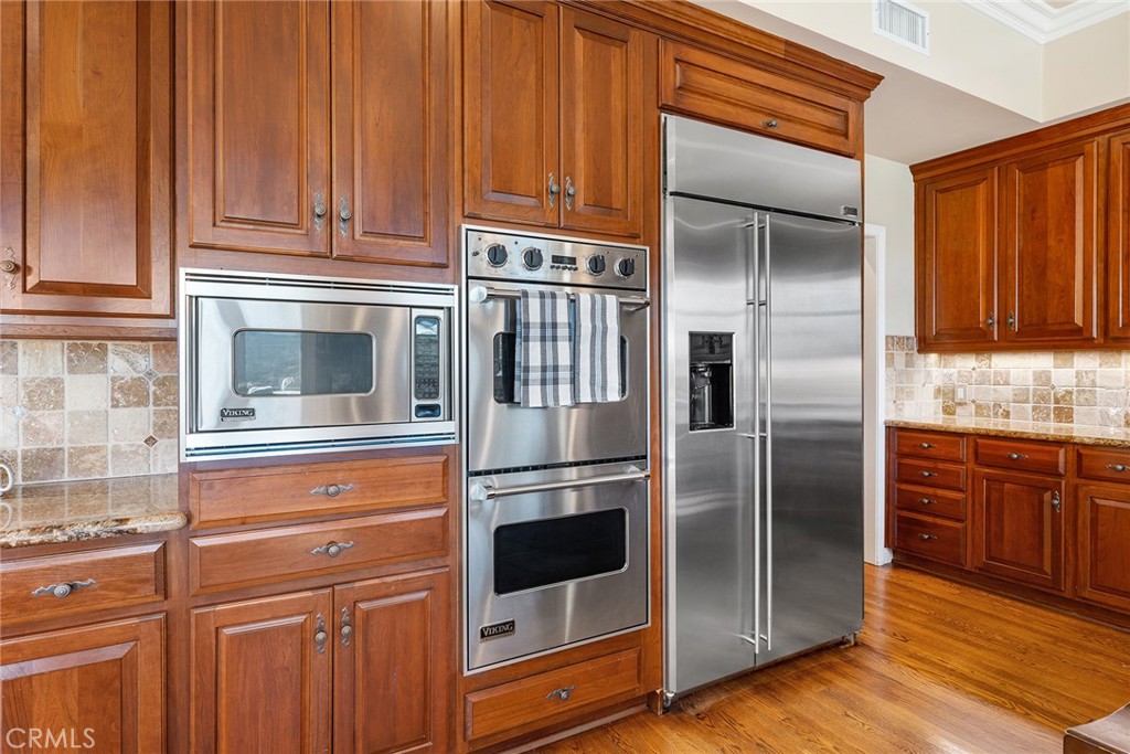 24920 Paseo Del Rancho Calabasas, CA 91302 - Photo 25 of 61 a kitchen with stainless steel appliances granite countertop a refrigerator and a stove top oven