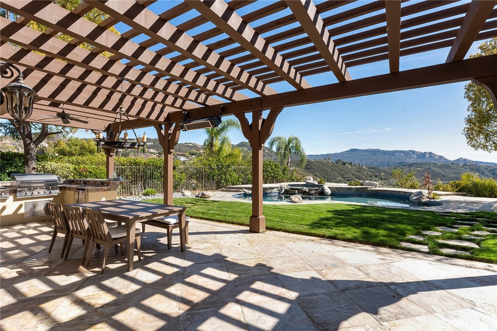 24920 Paseo Del Rancho Calabasas, CA 91302 - Photo 8 of 61 a view of a patio with a table chairs and a backyard