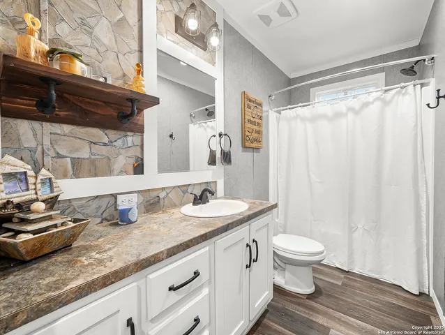 a bathroom with a granite countertop sink toilet and shower