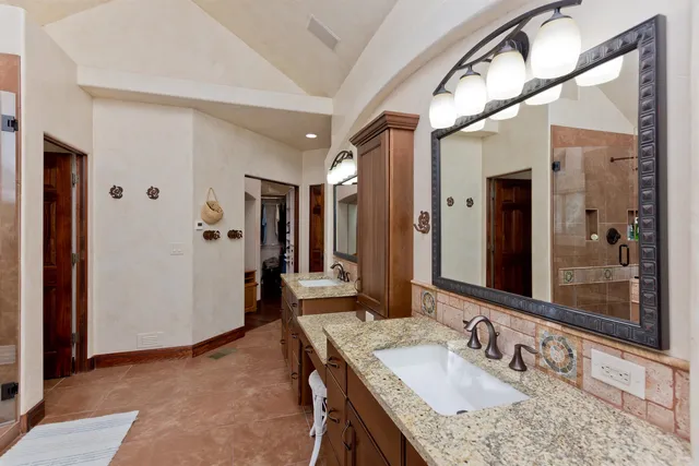 a bathroom with a granite countertop sink mirror and shower