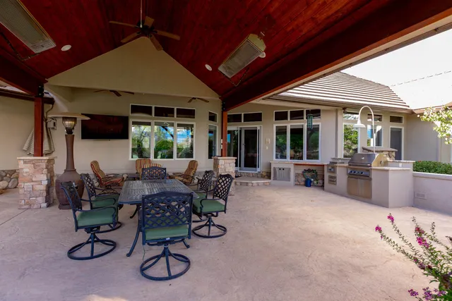 a view of a patio with dining table and chairs under an umbrella