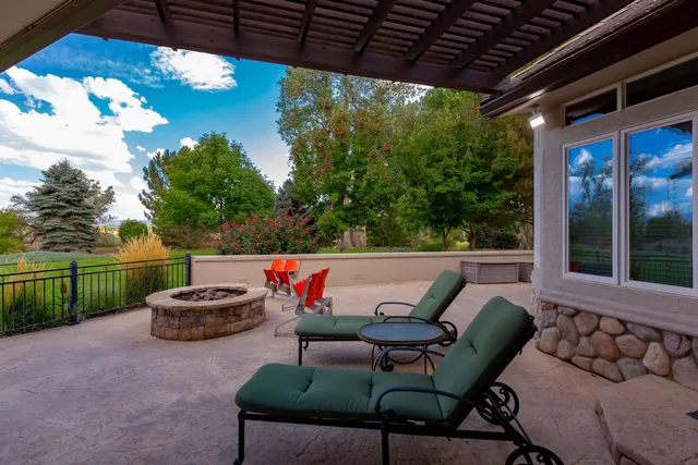 a roof deck with table and chairs and potted plants