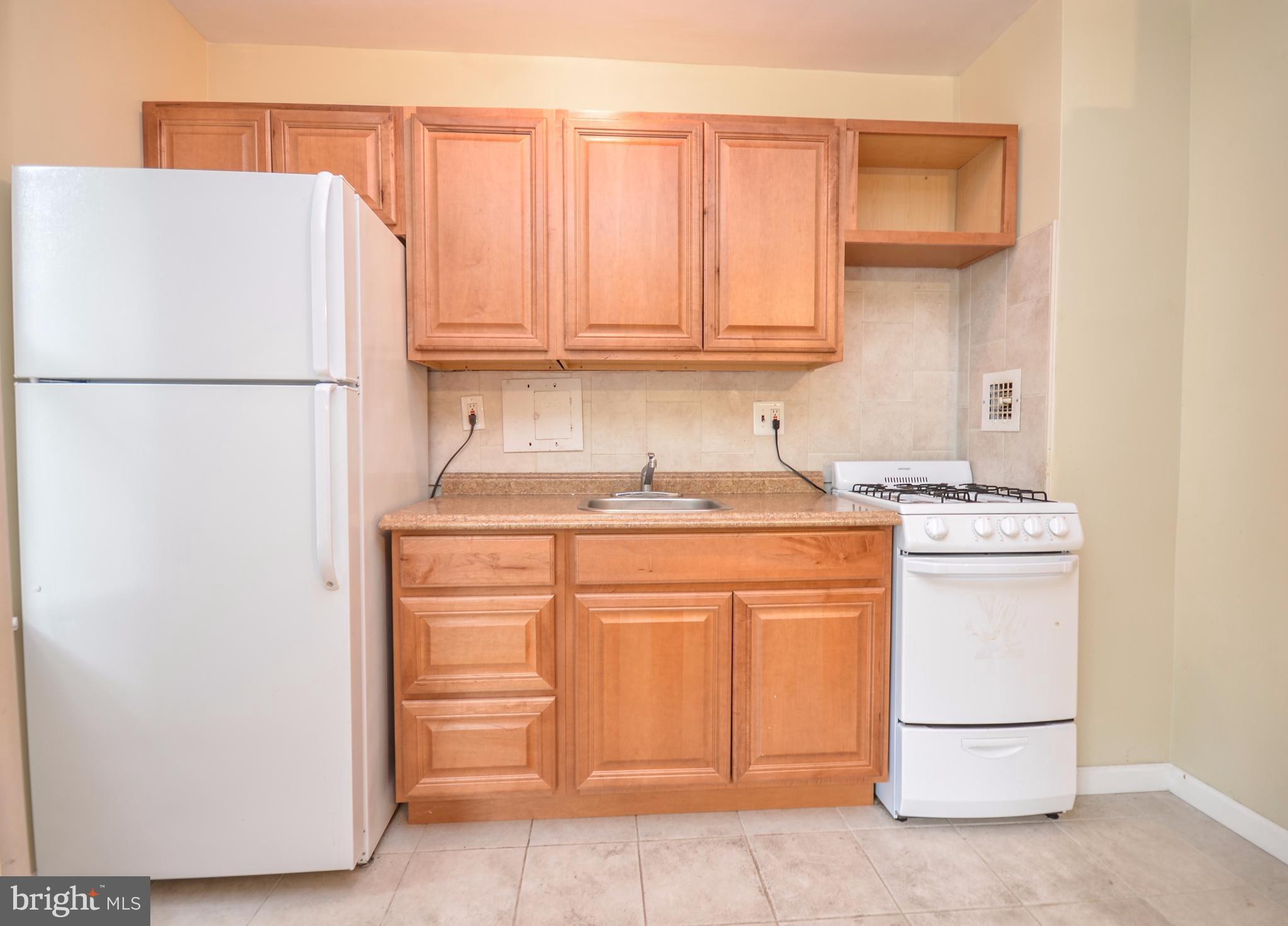 4100 W Street Northwest, Unit 303 Washington, DC 20007 - Photo 6 of 15 a kitchen with stainless steel appliances granite countertop a refrigerator sink and cabinets