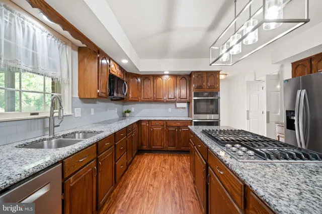 a dining room with wooden floor a chandelier a wooden table and chairs