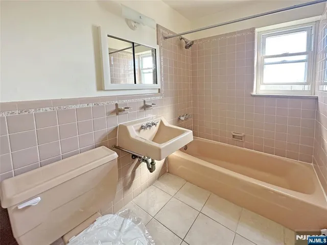 a bathroom with a tub sink and mirror