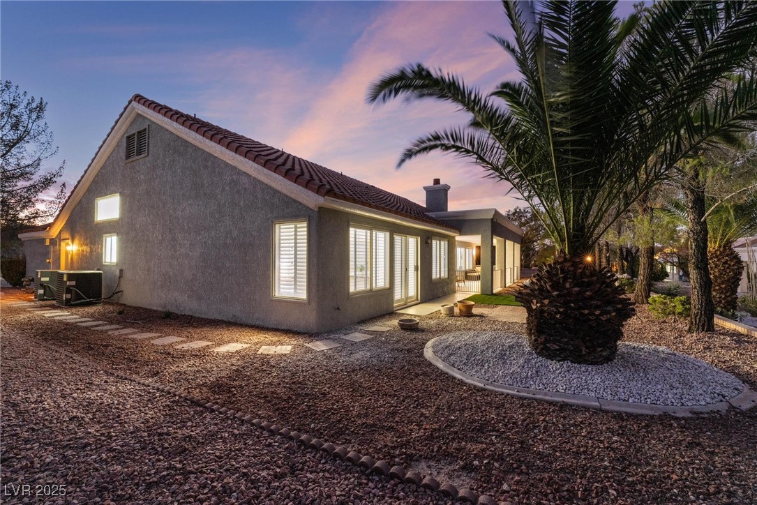 2528 Sunup Drive Las Vegas, NV 89134 - Photo 20 of 24 Property exterior at dusk featuring stucco siding, a patio, and a tile roof