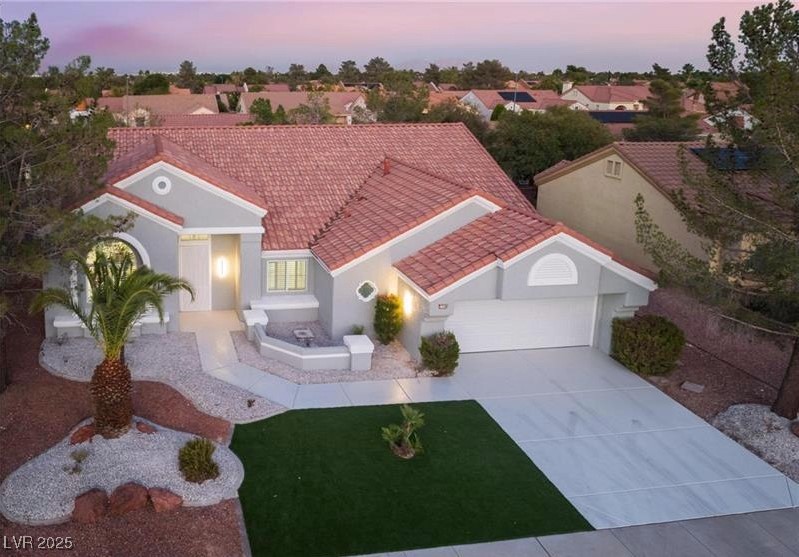 2528 Sunup Drive Las Vegas, NV 89134 - Photo 6 of 24 Mediterranean / spanish house featuring an attached garage, concrete driveway, stucco siding, and a tiled roof