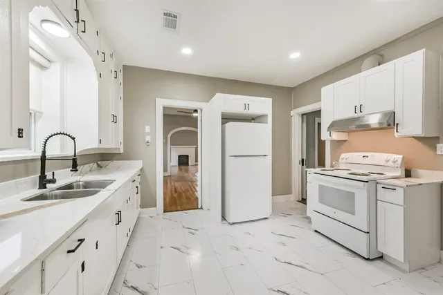 a kitchen with a stove top oven and refrigerator