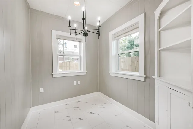 an empty room with wooden floor and a ceiling fan