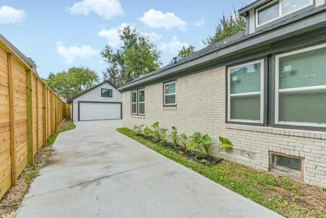 a view of a house with a yard and deck area under an umbrella