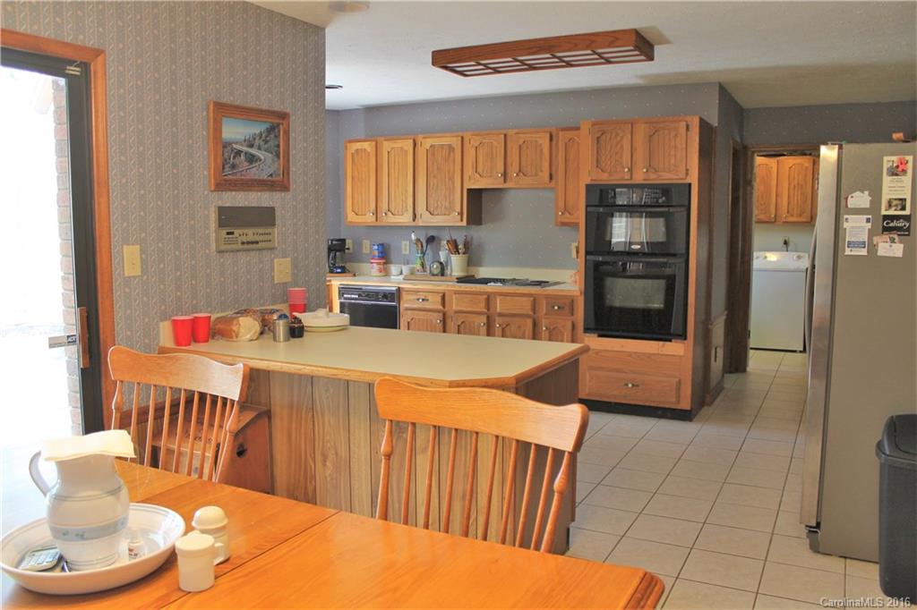 5214 Davis Road Waxhaw, NC 28173 - Photo 8 of 24 a kitchen with stainless steel appliances a refrigerator a sink a stove a table and chairs