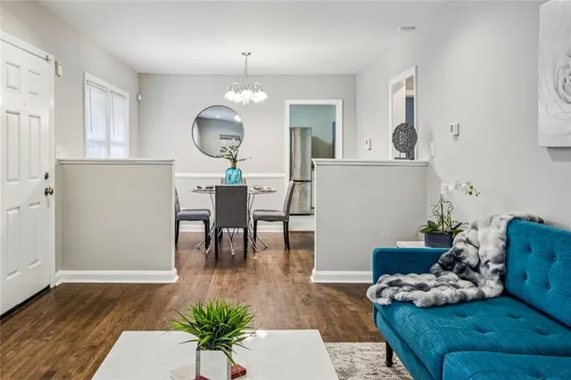 a view of a dining room with furniture a chandelier and wooden floor