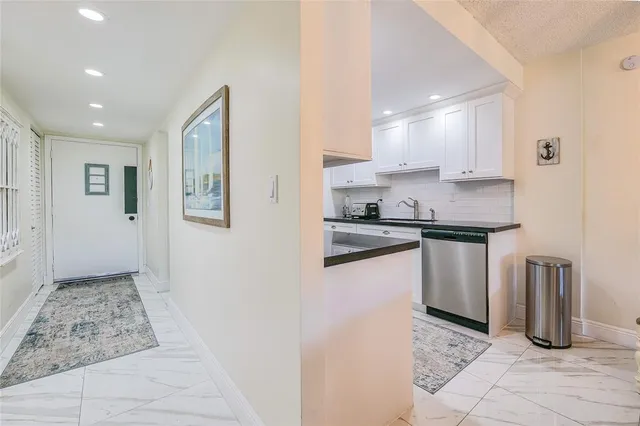 a kitchen with kitchen island granite countertop a sink a counter top space and cabinets