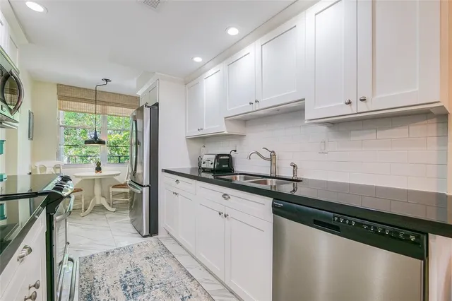 a kitchen with stainless steel appliances granite countertop a sink stove and cabinets