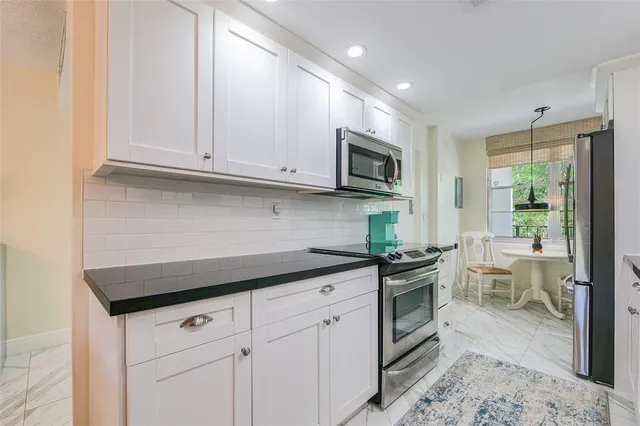 a kitchen with stainless steel appliances granite countertop a stove a sink and a microwave