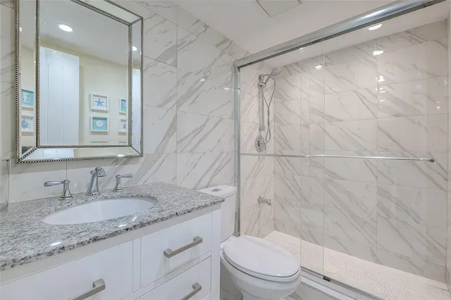 a bathroom with a granite countertop sink toilet and shower