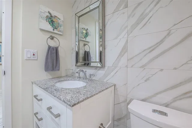 a bathroom with a granite countertop sink and a mirror