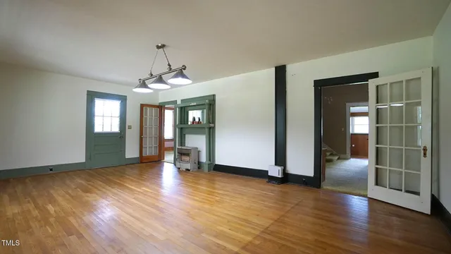 a view of a room with wooden floor and a window